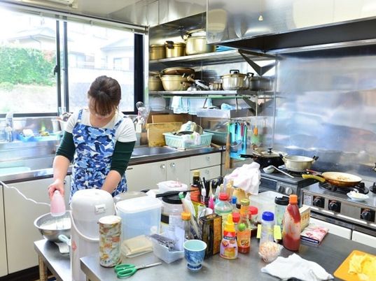 調理中の女性とキッチン