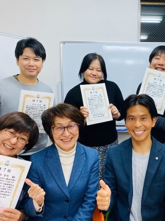 賞状を持つ人々の笑顔