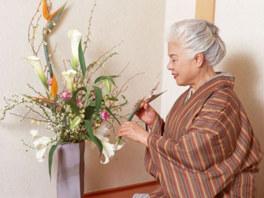 生け花をする笑顔の老女性