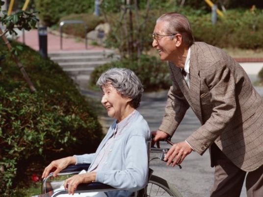 車椅子を押す笑顔の老人