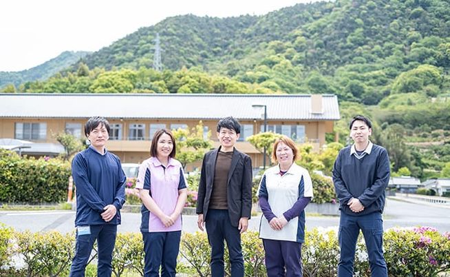 スタッフと緑に囲まれた施設外観