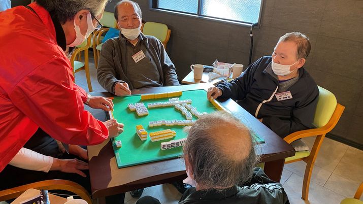 居室で麻雀を楽しむ人々