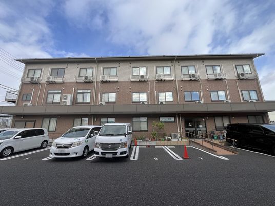 車が並ぶ駐車場の建物