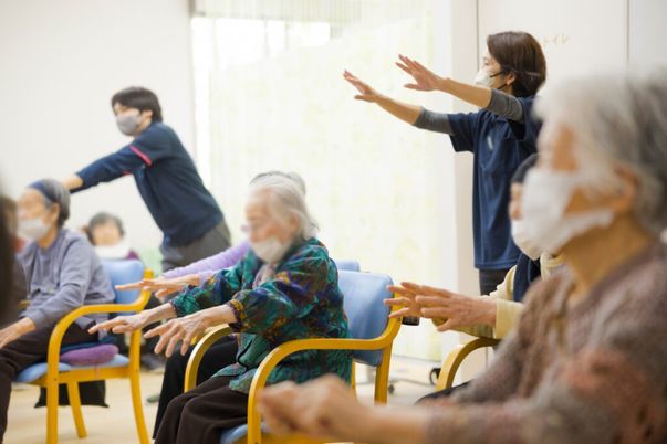 座って体操する人々