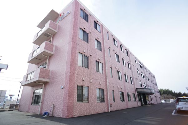 ピンクの外壁の建物エントランス