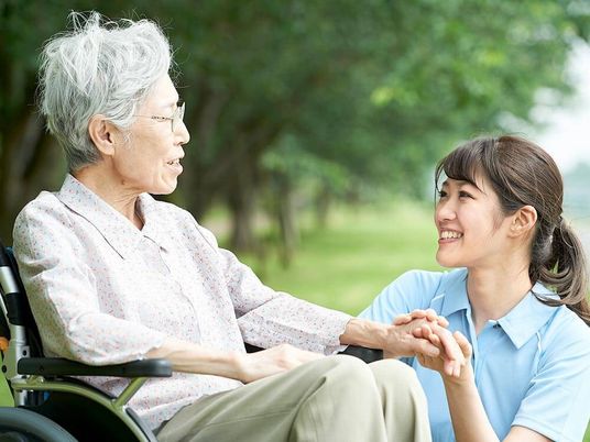 利用者と優しく手をつなぐ職員