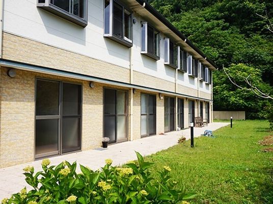緑豊かな庭のある施設外観