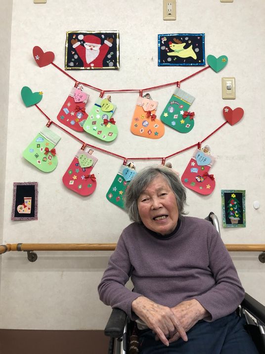 笑顔のおばあさんと壁飾り
