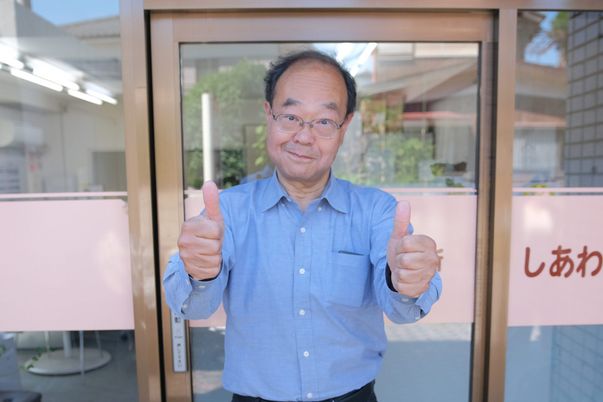 笑顔でサムズアップする人