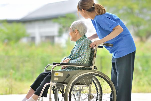 車椅子の高齢者と介助