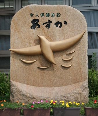 スズメの彫り物が施された石の看板