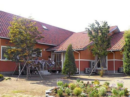 朱色の屋根の建物と庭