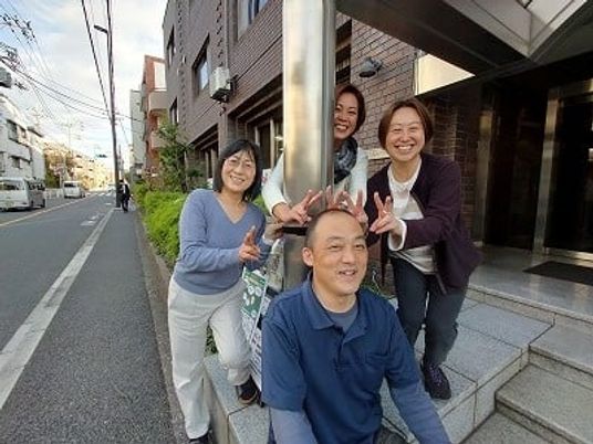 笑顔の人々が立つ入口前  