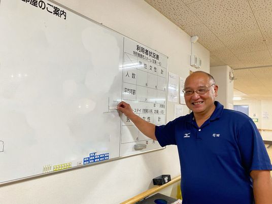 スタッフが掲示物を指差す様子