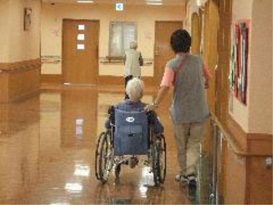 廊下で介助される高齢者