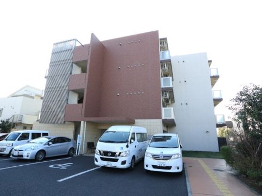 赤茶色の建物前の駐車場