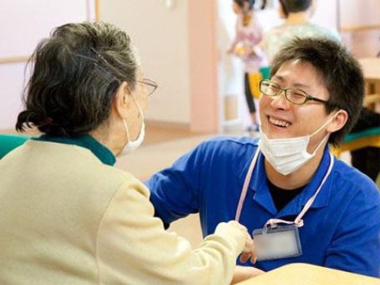 笑顔で手を握る介助者