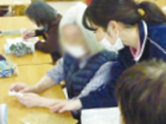 手元を見る女性と職員の様子