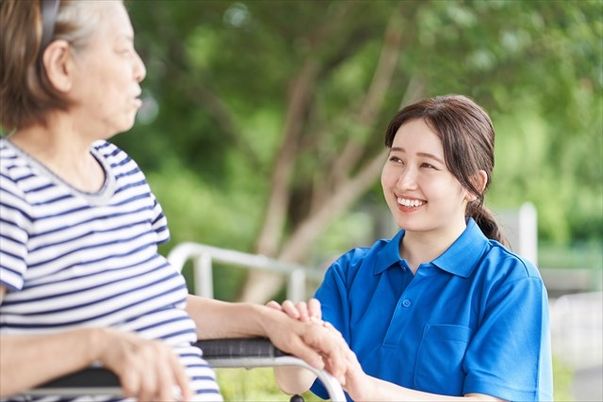 笑顔で手をつなぐスタッフと利用者