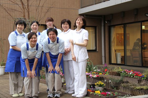 スタッフが笑顔で立つ中庭