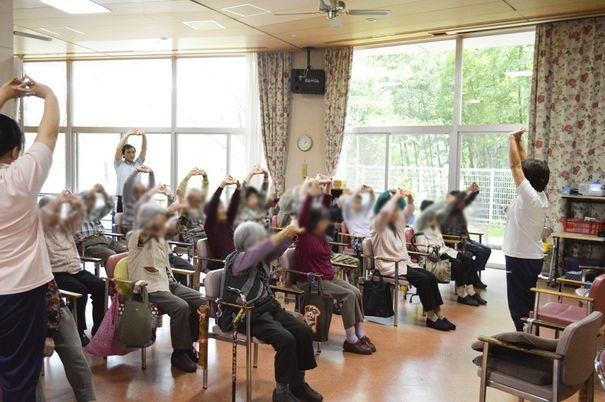 体操する人々がいる部屋