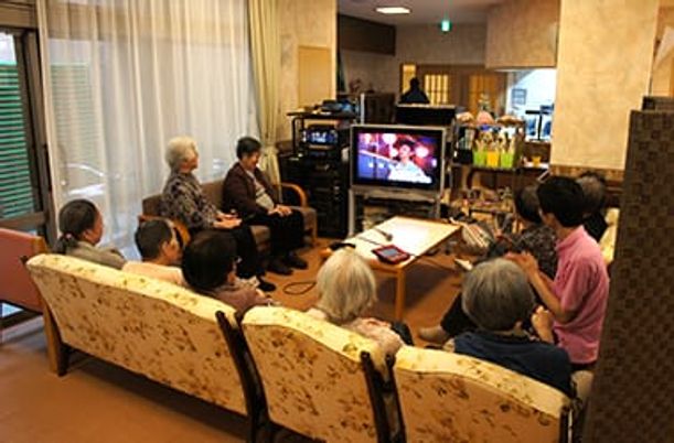 テレビを見る人々の居室