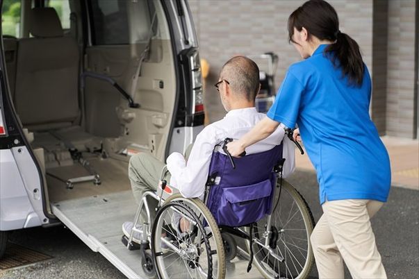 車椅子の男性とスタッフ