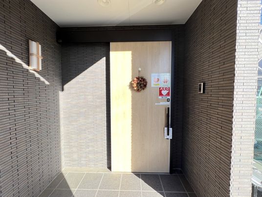 玄関とAEDの黒い壁