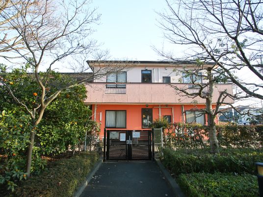 橙色の建物と緑濃い庭