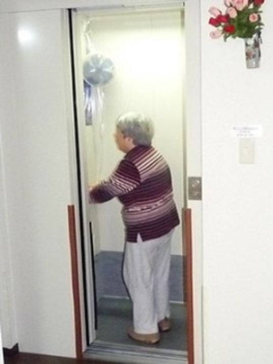 高齢者が扉を開ける様子