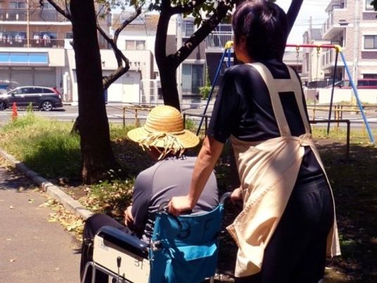 外でくつろぐ高齢者と介護者