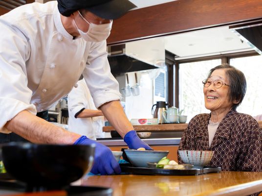 料理を受け取る笑顔の女性