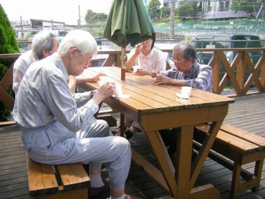 屋外テーブルで休憩する人々