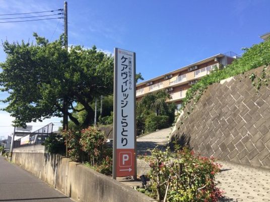 快晴の看板と緑豊かな坂