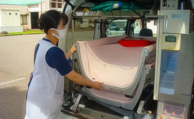 介護士が入浴車を整える場面