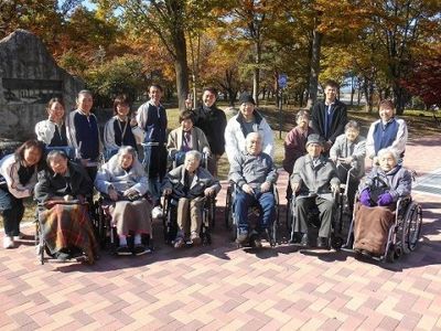 集合する人々と秋の木々