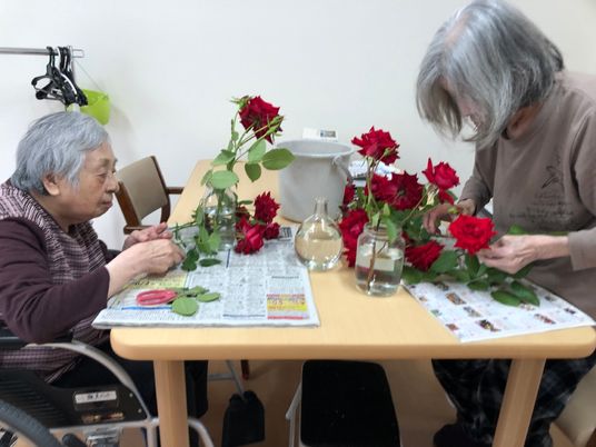 花を生ける高齢者二人
