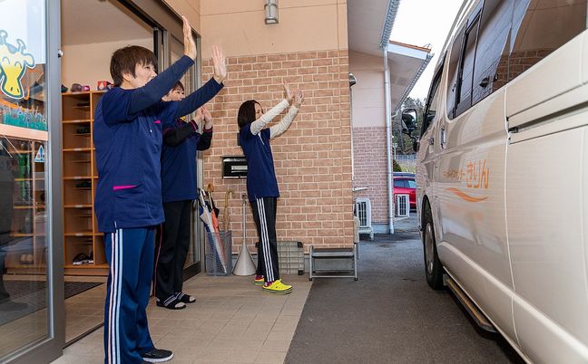 スタッフが見送りする玄関