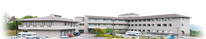 周囲に車が並ぶ建物の外観