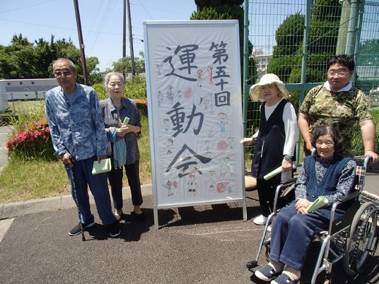 集う人々と看板