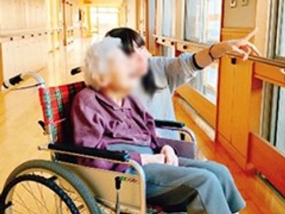 車椅子の利用者と介護士の廊下